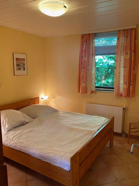 Knusse slaapkamer van Vakantiehuis Slufterhoek 128 in De Cocksdorp, Texel met raam uitzicht.