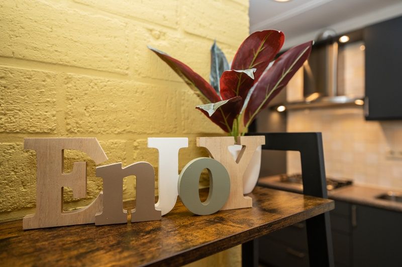 Decoratief detail in Vakantiehuis 34A, De Cocksdorp, Texel met de woorden 'Enjoy'.