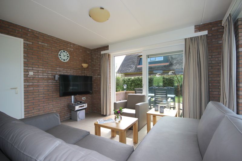 Gezellige woonkamer van Bungalow De Witte Hoek 6 Pers. in De Cocksdorp, Texel met uitzicht op de tuin.