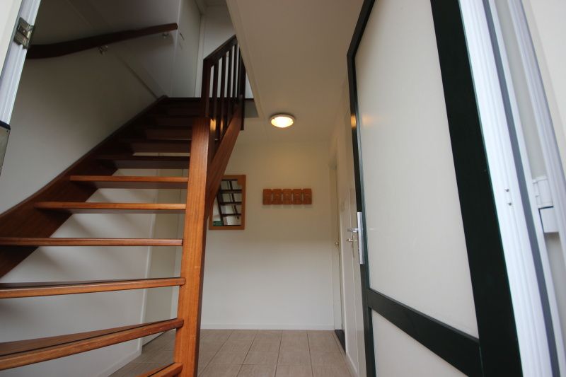 Ingang met trap in Bungalow De Witte Hoek 6 Pers. in De Cocksdorp, Texel, met houten details.