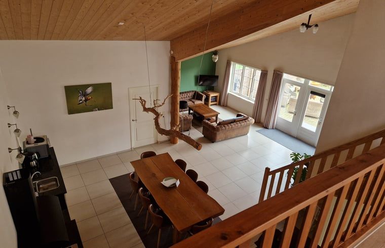 Geraeumiges Wohnzimmer in Cottage in De Cocksdorp, Texel mit Holzinterieur und grossen Fenstern, ideales Ferienhaus auf den Watteninseln.