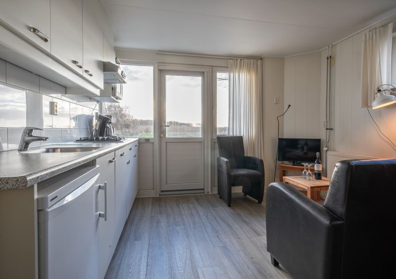 Moderne Kueche im Ferienhaus Kikkertstraat 60, De Cocksdorp, Texel mit Blick auf die Landschaft.