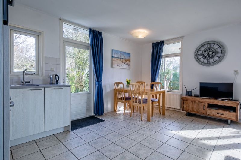 Ruime eetkamer met uitzicht op de tuin in Vakantiehuis Slufterduin 52a, De Cocksdorp, Texel.