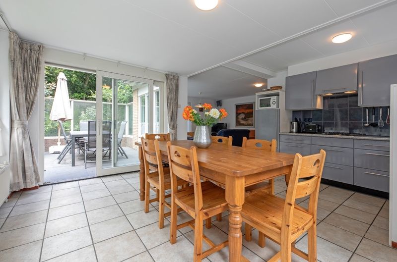 Essecke mit Blumen im Ferienhaus Slufterduin 098, De Cocksdorp, Texel mit Zugang zur Terrasse.