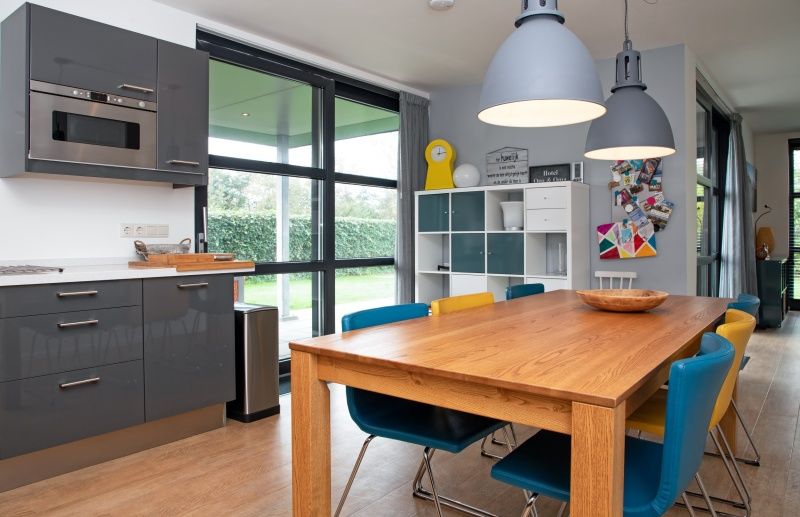 Bright dining area in Holiday home Slufteroord 240, De Cocksdorp with garden views and colorful chairs.