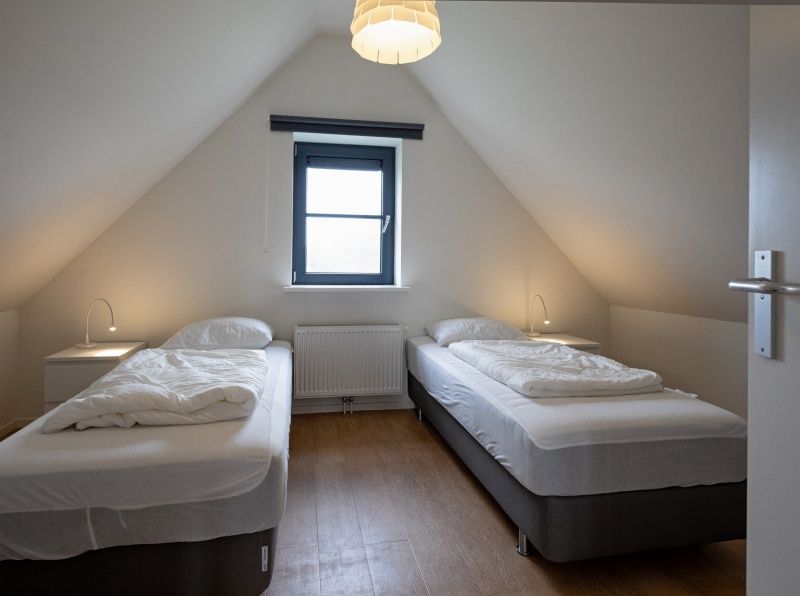 Cozy attic room in Holiday home Slufteroord 240, De Cocksdorp with two beds and a skylight.