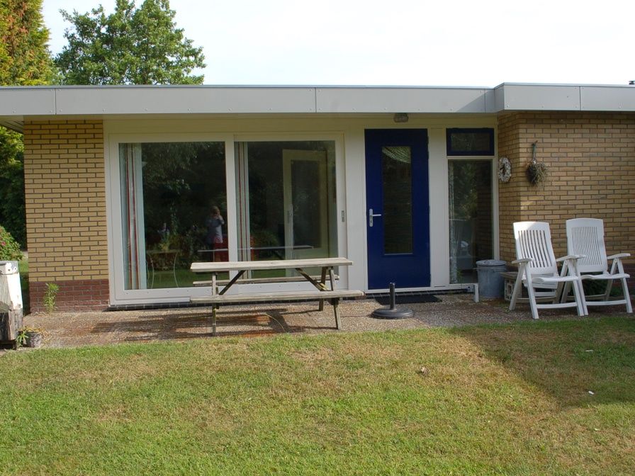 Bungalow Tamarisk 212 in De Cocksdorp, Texel mit einer einladenden Terrasse und gruener Umgebung.