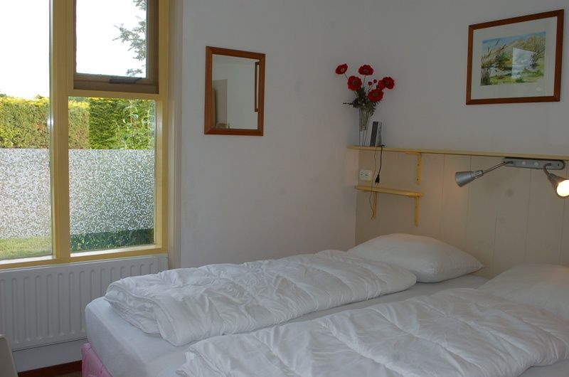 Schlafzimmer mit Doppelbett im Bungalow Tamarisk 212, De Cocksdorp, Texel fuer hoechsten Komfort.