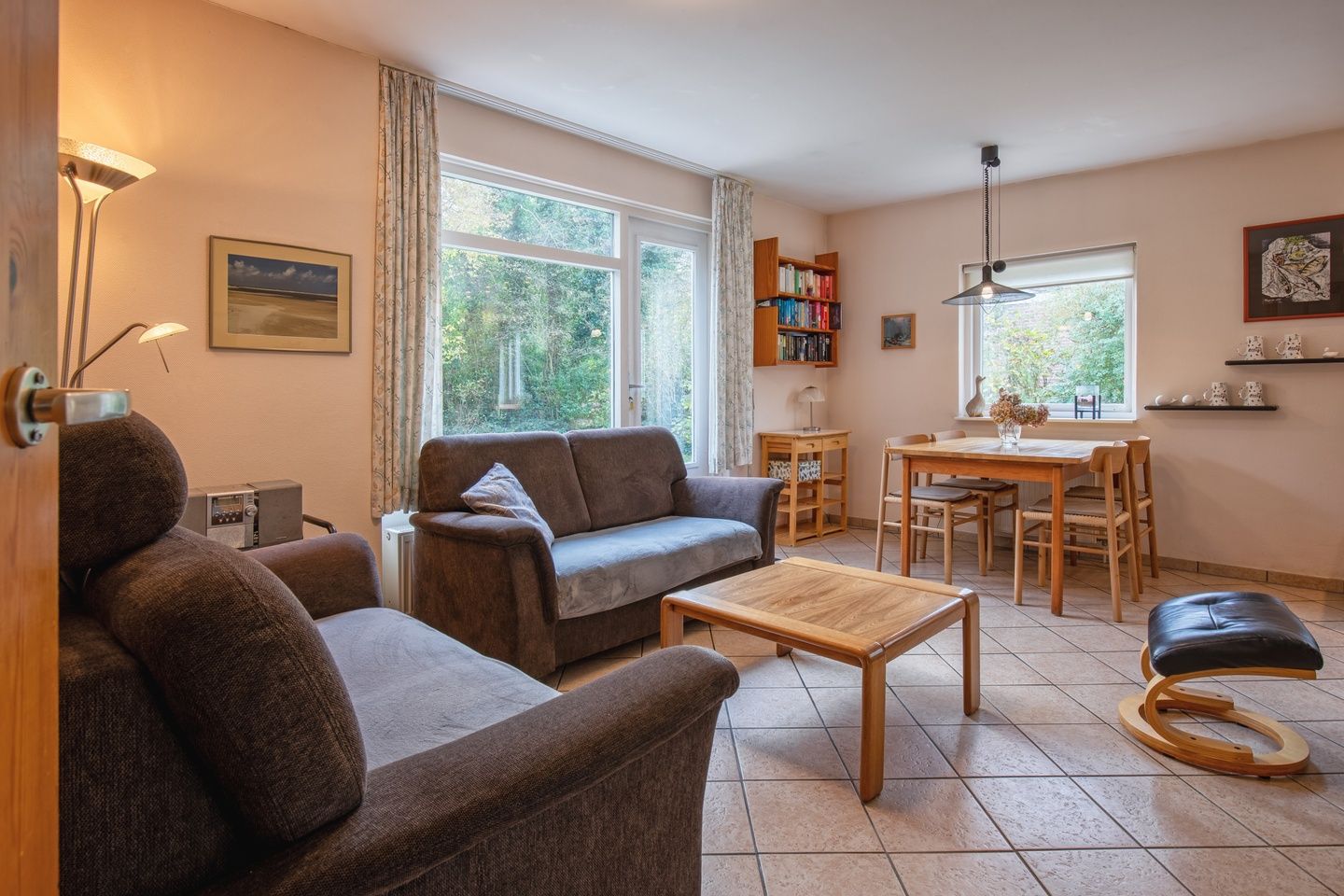 Cozy living room of Holiday home Slufterduin 094 in De Cocksdorp, Texel. Comfortable seating area overlooking the green surroundings.
