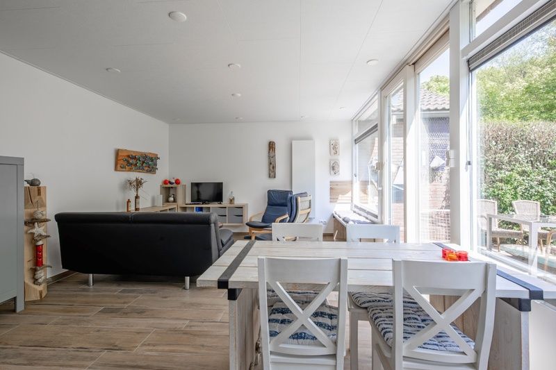 Lichte woonkamer van Vakantiehuis Slufterhoek 158 in De Cocksdorp, Texel, met moderne inrichting en uitzicht op de tuin.