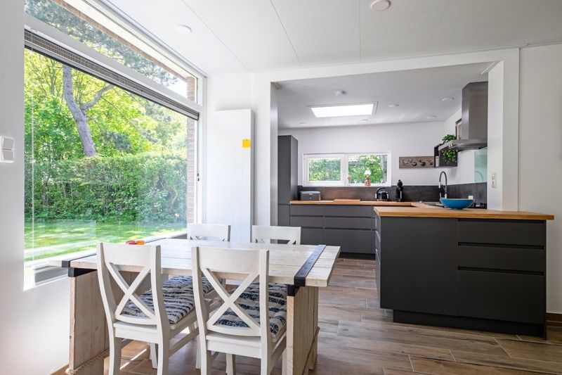 Moderne keuken en eetruimte in Vakantiehuis Slufterhoek 158, De Cocksdorp, Texel, met uitzicht op de groene tuin.