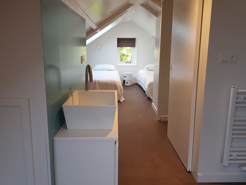 Zolderkamer met twee bedden in Bungalow Schelpenoord - Vakantiehuis De Oester, De Cocksdorp, Texel, met dakraam en modern interieur.