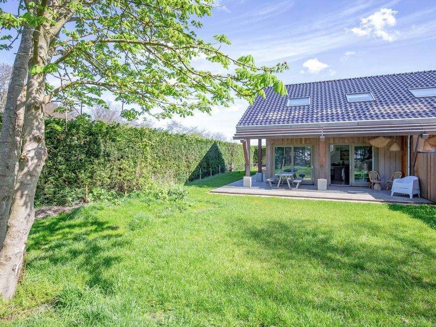 Quiet garden at Holiday home De Razende Bol in De Cocksdorp, Texel, with spacious veranda and green surroundings.