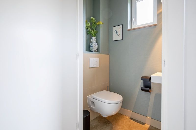Modern toilet in Holiday Home De Razende Bol, De Cocksdorp, Texel, with sleek design and natural light.