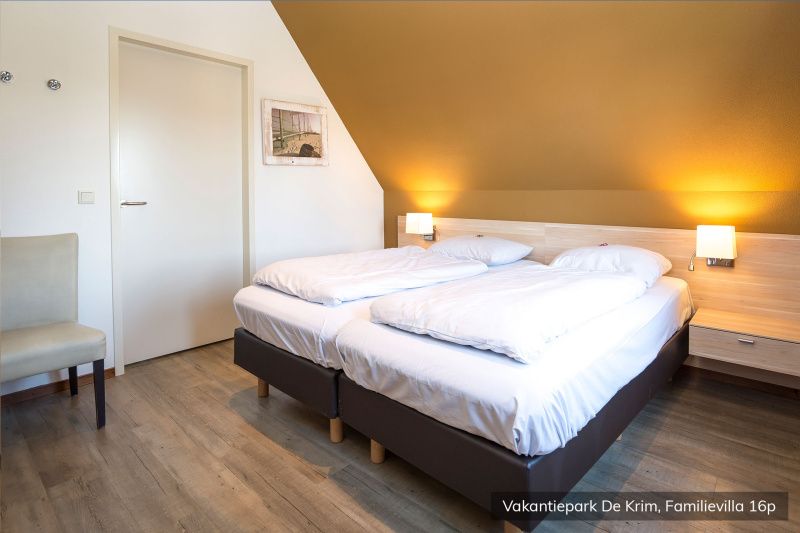 Cozy bedroom in Family Villa 16 persons, De Cocksdorp, Texel with comfortable beds.