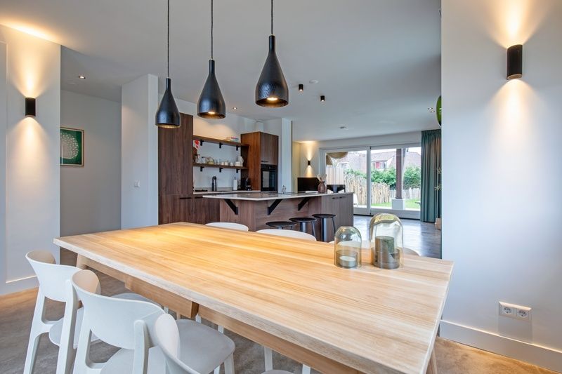 Eetkamer van Vakantiehuis Griend, Texel met houten tafel en sfeervolle verlichting.