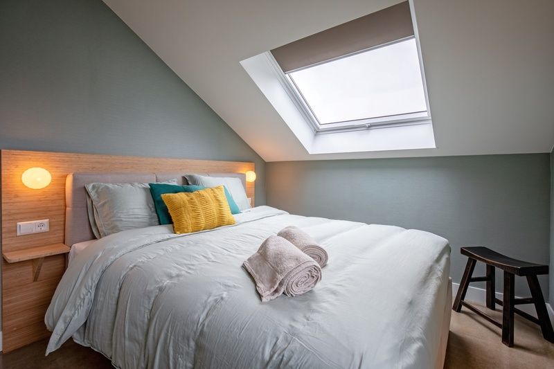 Slaapkamer in Vakantiehuis Griend, Texel met comfortabel bed en dakraam.