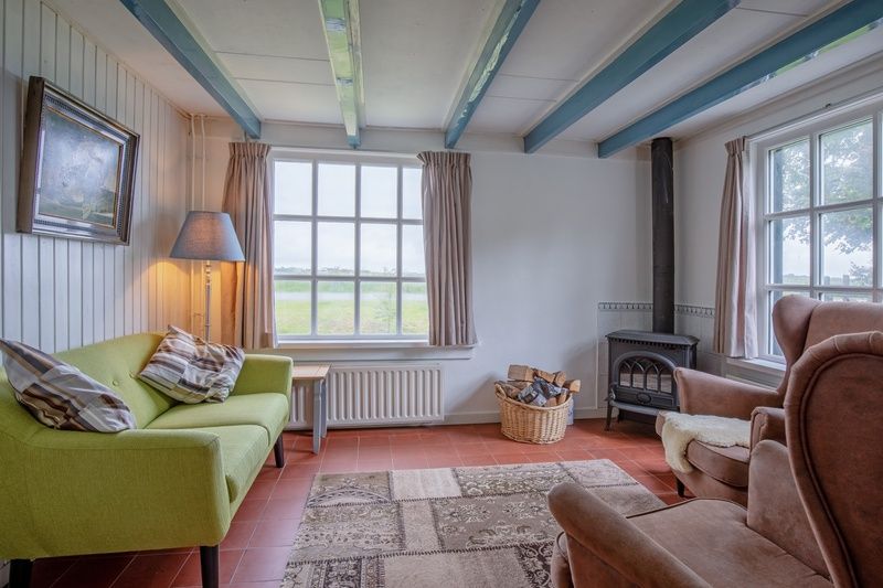 Gezellige woonkamer van vakantiehuis Muyweg 062 in De Cocksdorp, Texel met uitzicht op groene velden.