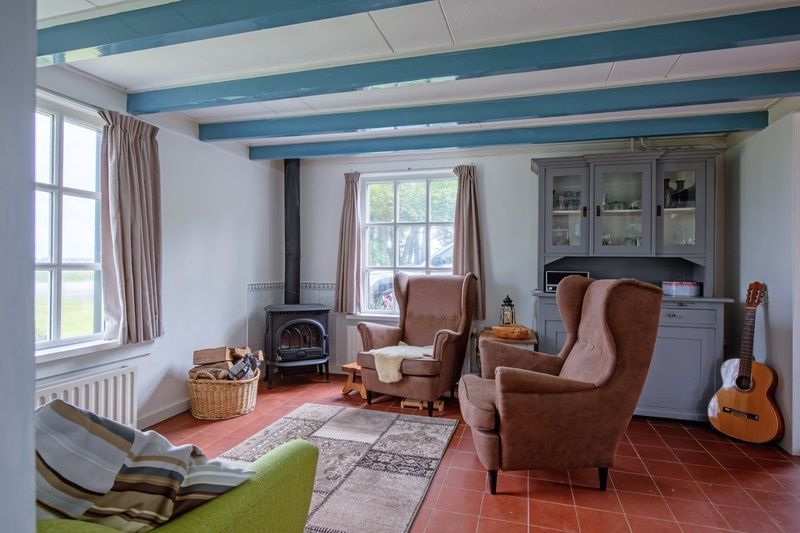 Knusse zithoek in vakantiehuis Muyweg 062, De Cocksdorp, Texel met comfortabele fauteuils en houtkachel.