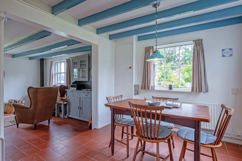 Eetkamer in vakantiehuis Muyweg 062, De Cocksdorp, Texel met houten tafel en stoelen voor gezellige maaltijden.