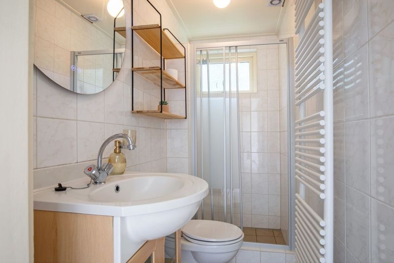 Moderne badkamer in Huisje Krimweg, vakantiewoning in De Cocksdorp Texel met douche en wastafel.