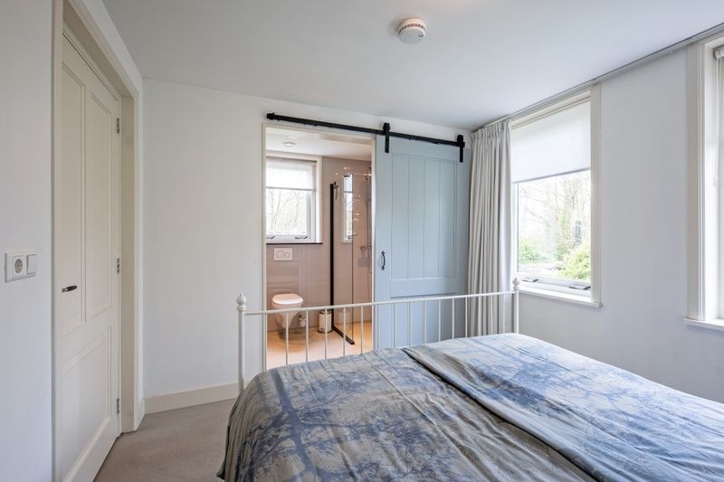 Slaapkamer met ensuite badkamer in Bungalow Postweg 109, De Cocksdorp, Texel. Luxe vakantiehuis op de Waddeneilanden.