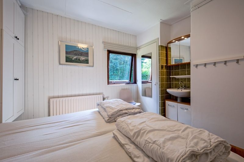 Helles Schlafzimmer mit eigenem Badezimmer im Ferienhaus Slufterduin 092, De Cocksdorp, Texel, fuer einen entspannten Aufenthalt.