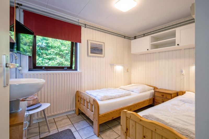 Zweites Schlafzimmer im Ferienhaus Slufterduin 092, De Cocksdorp, Texel mit zwei Einzelbetten und gemuetlicher Einrichtung.