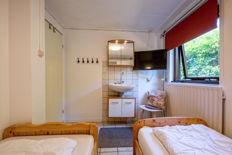 Modernes Badezimmer im Ferienhaus Slufterduin 092, De Cocksdorp, Texel, mit Waschbecken und Spiegel fuer Komfort waehrend Ihres Aufenthalts.