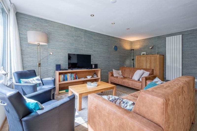 Stylish sitting room in Holiday home Slufterhoek 132, De Cocksdorp, Texel with modern furnishings and lots of natural light.