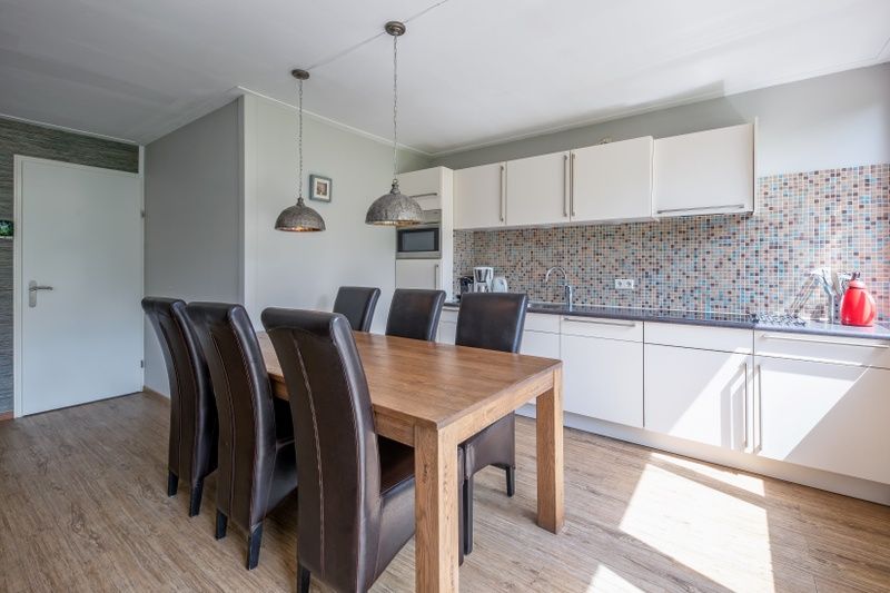 Modern kitchen of Holiday home Slufterhoek 132 in De Cocksdorp, Texel with dining table and stylish furnishings.