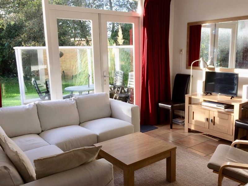 Zonnige woonkamer met uitzicht op de tuin in Vakantiehuis Slufteroord 270, Bungalowpark Slufteroord, Texel.