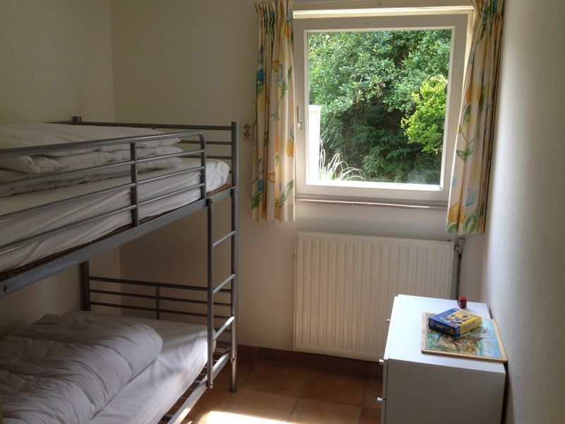Kinderkamer met stapelbed in Vakantiehuis Slufteroord 270, Bungalowpark Slufteroord, Texel met uitzicht op groen.