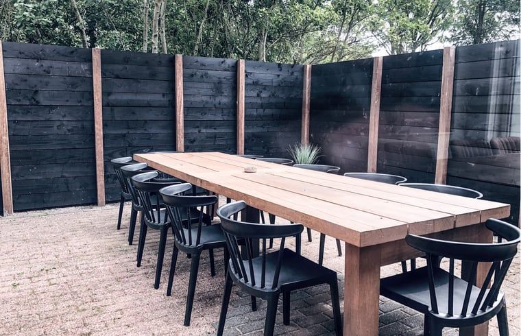 Buitenterras van Vakantiehuis in De Cocksdorp, Texel met grote eettafel.