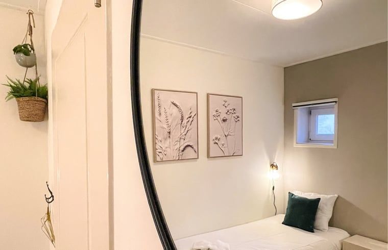 Knusse slaapkamer in Vakantiehuis in De Cocksdorp, Texel met natuurlijke accenten.