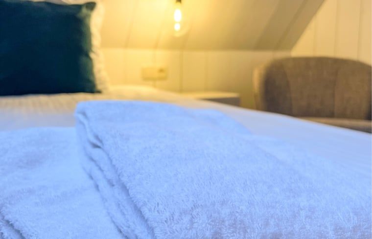 Comfortabele bedden in Vakantiehuis in De Cocksdorp, Texel met zachte handdoeken.