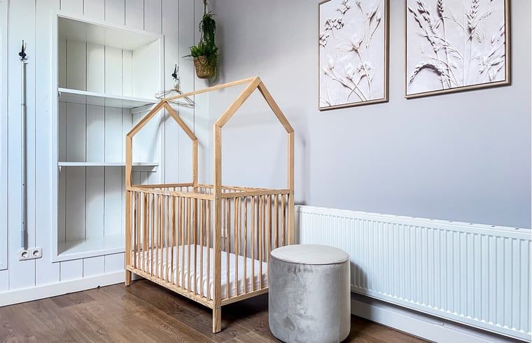 Kinderhoek in Vakantiehuis in De Cocksdorp, Texel met houten ledikant.