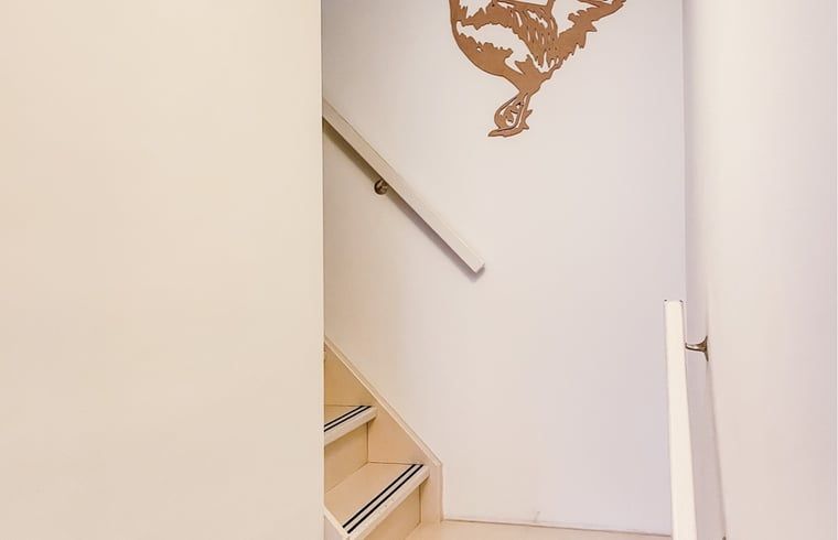 Trapopgang in Vakantiehuis in De Cocksdorp, Texel met decoratieve muursticker.