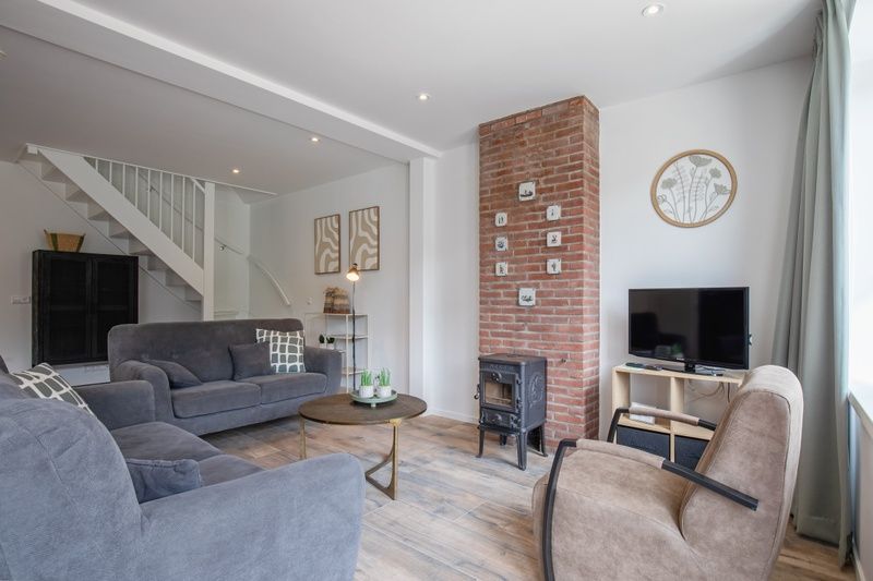 Gezellige woonkamer van Vakantiehuis Slufterhoek 104 in De Cocksdorp, Texel met comfortabele zitplaatsen en sfeervolle inrichting.