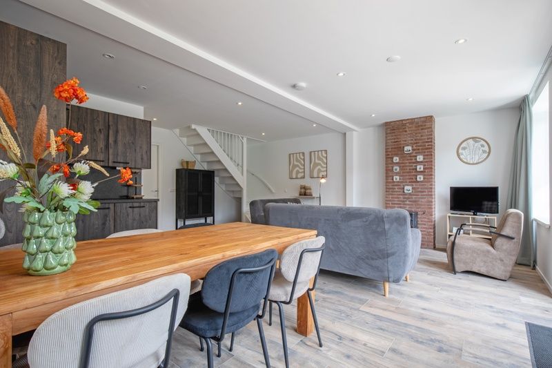 Stijlvolle eetkamer in Vakantiehuis Slufterhoek 104, De Cocksdorp, Texel met houten tafel en moderne keuken.