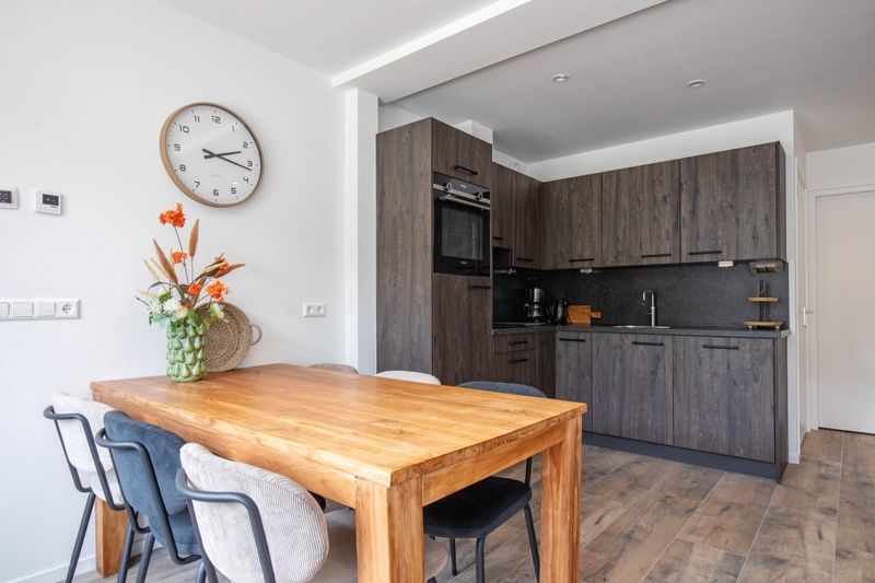 Moderne keuken in Vakantiehuis Slufterhoek 104, De Cocksdorp, Texel met houten eettafel en stijlvolle inrichting.