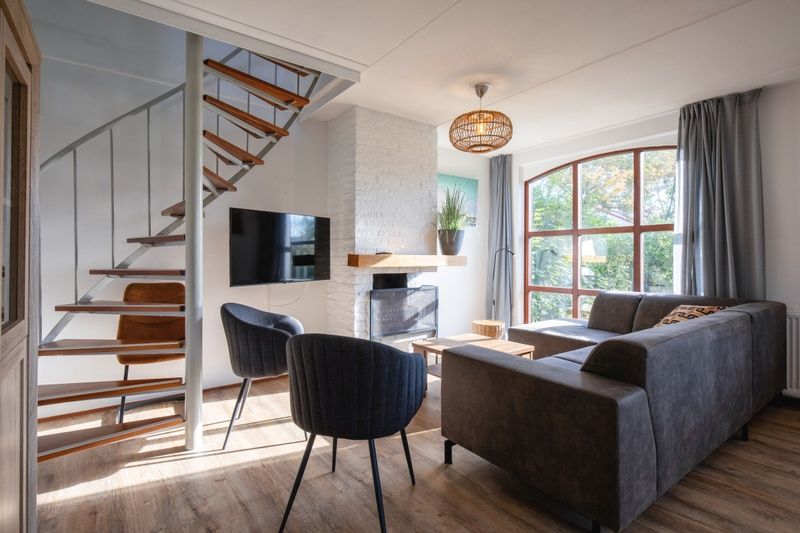 Gezellige woonkamer in Villapark Residentie Texel nr. 711, vakantiehuis in De Cocksdorp, Texel met moderne inrichting en grote ramen.