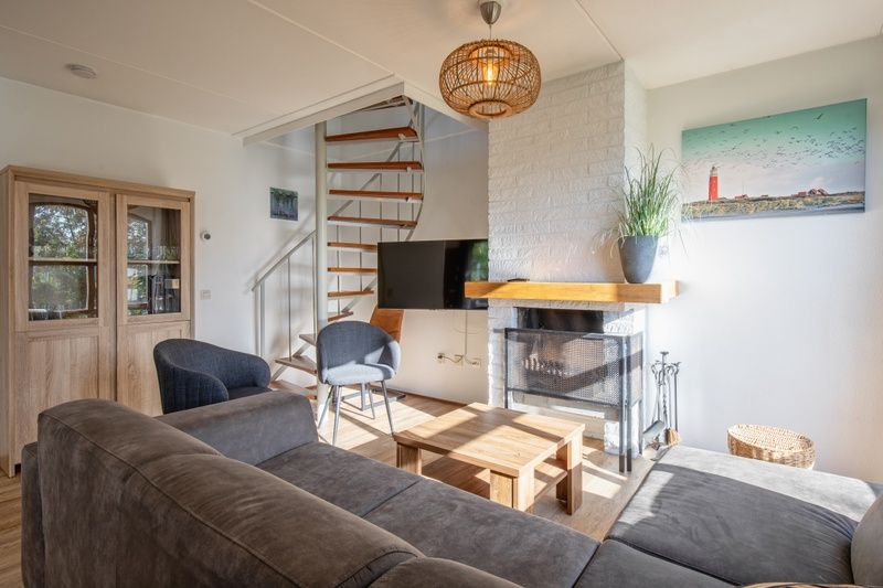 Gezellige woonkamer in Villapark Residentie Texel nr. 711, vakantiehuis in De Cocksdorp, Texel, met open haard en moderne inrichting.