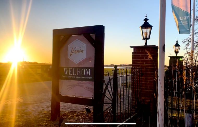 Entree van Vakantiehuisje in De Cocksdorp, Texel bij zonsondergang, verwelkomt gasten met een warme sfeer op de Waddeneilanden.