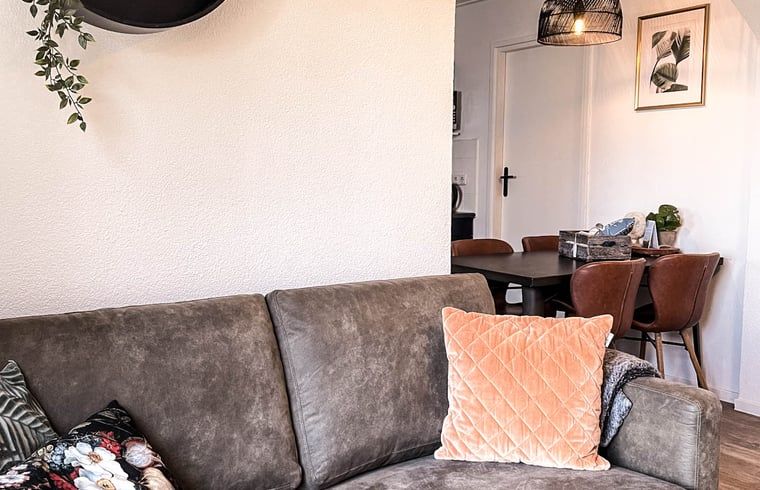 Gezellige woonkamer van Vakantiehuisje in De Cocksdorp, Texel met comfortabele bank en eethoek, ideaal voor een ontspannen vakantie.