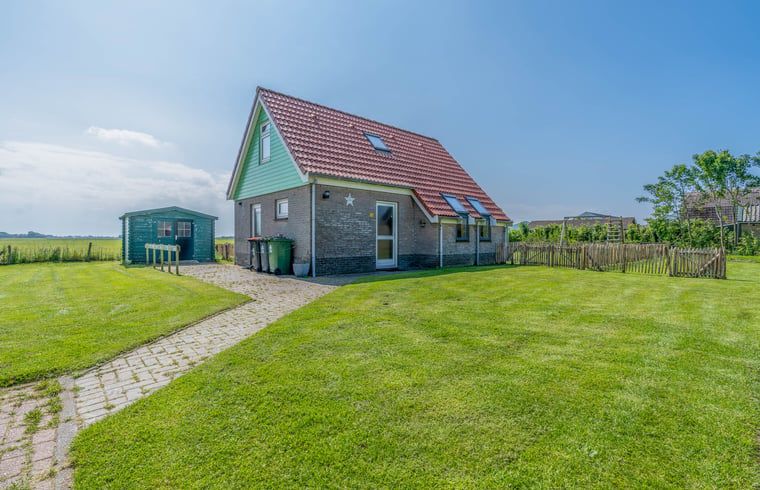 Vakantiehuisje in De Cocksdorp, Texel met groene tuin en uitzicht op de Waddeneilanden, ideaal voor een ontspannen verblijf in de natuur.