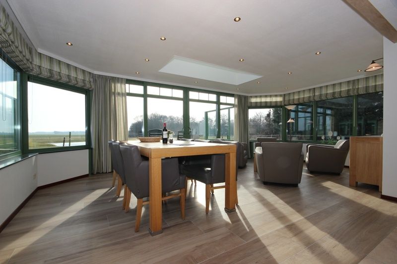 Ruime eetkamer met panoramisch uitzicht in Villa De Witte Hoek serre huisdiervrij, De Cocksdorp Texel, ideaal voor gezellige diners.