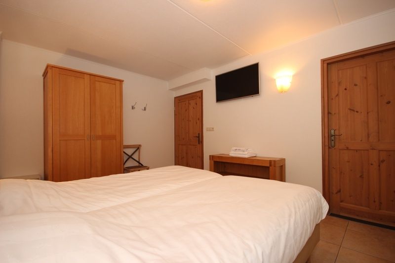 Slaapkamer met tweepersoonsbed in Villa De Witte Hoek serre huisdiervrij, De Cocksdorp Texel, biedt comfort en rust voor een goede nachtrust.