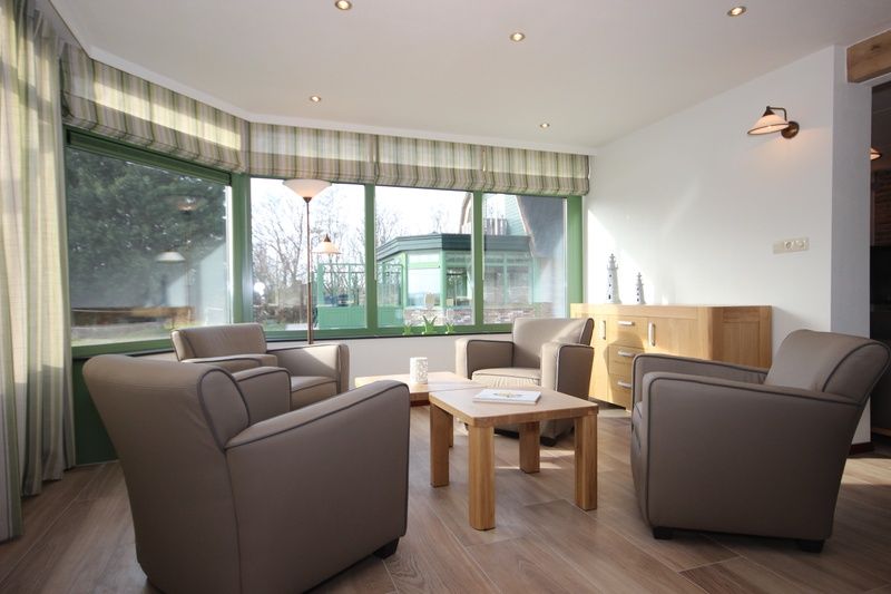 Lichte serre in Villa De Witte Hoek huisdiervrij, De Cocksdorp Texel, biedt een gezellige zithoek met uitzicht op de tuin.