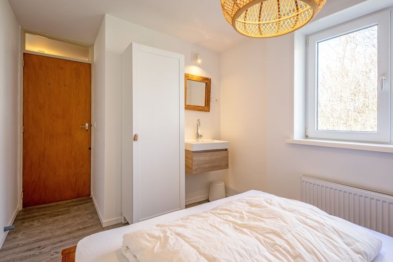 Slaapkamer met wastafel in Vakantiehuis Slufteroord 292, Bungalowpark Slufteroord, De Cocksdorp, Texel, ideaal voor comfort.